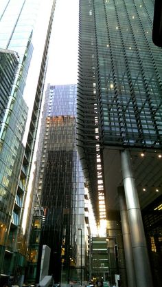 the tall buildings are all glass and have many windows on them, as well as street lights