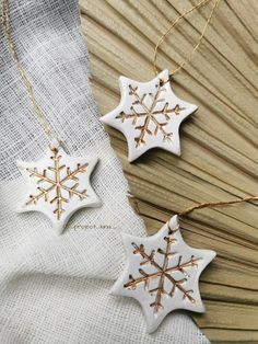 two white and gold snowflake ornaments on a table