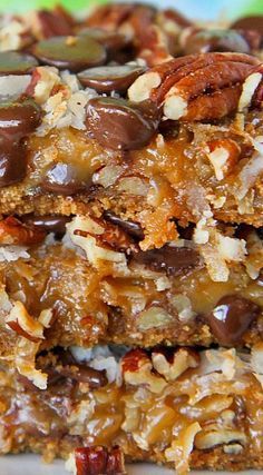 three pieces of granola bars stacked on top of each other with nuts and chocolate