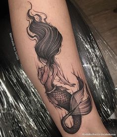 a woman's leg with a mermaid tattoo on it