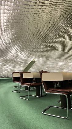 three chairs are lined up in front of a metal wall that is covering the ceiling