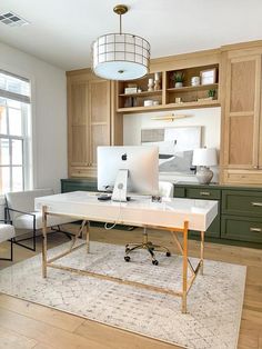 a desk with a computer on top of it in a room filled with wooden cabinets