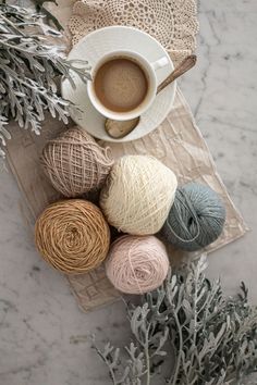 balls of yarn next to a cup of coffee