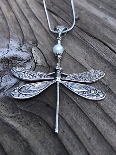 Large silver and pearl dragonfly pendant.This large silver dragonfly pendant is really stunning! Will definitely stand out in a crowd. Excellent gift for any dragonfly lover in your life, including yourself!The dragonfly totem carries the wisdom of transformation and adaptability in life. As spirit animal, the dragonfly is connected to the symbolism of change and light. When the dragonfly shows up in your life, it may remind you to bring a bit more lightness and joy into your life.The dragonfly Dragonfly Totem, Silver Dragonfly Necklace, Celtic Earrings, Dragonfly Jewelry, Accessory Ideas, Jewelry Styles, Mermaid Jewelry, Dragonfly Necklace, Dragonfly Earrings