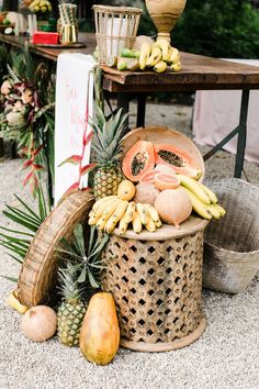 various fruits and vegetables on display in baskets at an outdoor market stall, including pineapples