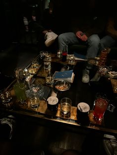 a man sitting at a table filled with drinks