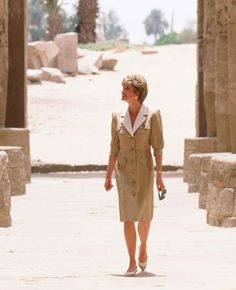 a woman is walking through an egyptian temple