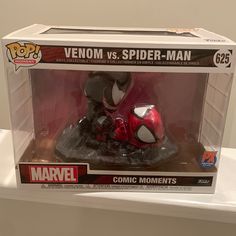 a red and black spider - man motorcycle in a box on top of a shelf