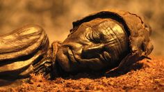 an old pair of gloves sitting on top of the ground next to each other in dirt