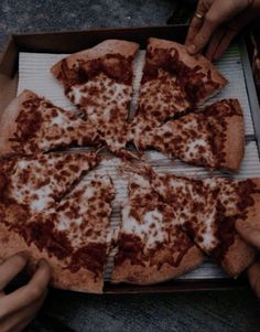 a pizza sitting on top of a pan covered in cheese and brown sauce slices are being taken out of it