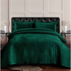 a bed with green bedspread and pillows