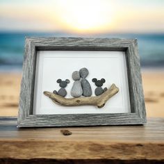 some rocks are placed in a frame on the beach