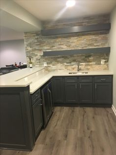 an empty kitchen with gray cabinets and white counter tops is seen in this image from the doorway