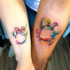 two people with matching tattoos on their arms, both have mickey and minnie mouse heads