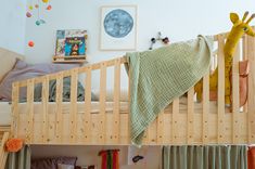 a child's bed with a giraffe blanket hanging from the top bunk