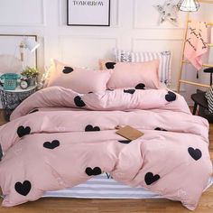 a pink bed with black hearts on it