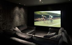 a couple of people riding bikes on a screen in a room with two couches