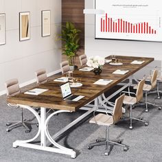 a large conference table with chairs around it and a laptop on the table in front of it