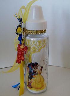 a baby bottle with a disney character on the side and a yellow ribbon around it