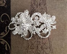 Rhinestone brooch, crystal brooch, wedding brooch, rhinestone brooch pin, crystal pin broochThis rhinestone brooch is  2 " long. (5 cm)Silver color metal base, clear crystals. Pin in the back. Nickel and lead free.This listing is for ONE brooch. You can add it to a hair-band, hair-clip, alligator clip, hair comb, sash, wedding ring bearer pillow, wedding bouquet, flowers... ===================SHIPPING========================Will be shipped within 2 business days via USPS First class mail with de Glamorous Crystal Brooch As Gift, Glamorous Crystal Brooches For Gifts, Silver Crystal Brooches For Gift, Elegant Crystal Pins For Party, Glamorous Crystal Brooches As Gift, Silver Crystal Brooches As Gift, Elegant Silver Crystal Pins, Crystal Brooch For Wedding, Crystal Brooch For Wedding Jewelry