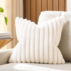 a white pillow sitting on top of a couch