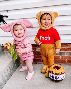 two toddlers dressed in costumes standing next to each other