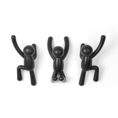 three black plastic figurines with one holding up the other's arms and legs