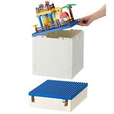 two legos are shown with one being opened and the other is holding a toy boat