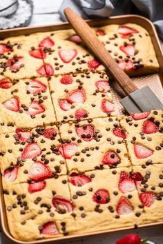 a pan filled with cookies and strawberries on top of a table