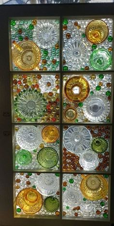 a window with many different colored glass plates in it's center and bottom section