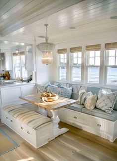 a kitchen with white walls and wooden flooring next to a breakfast nook table