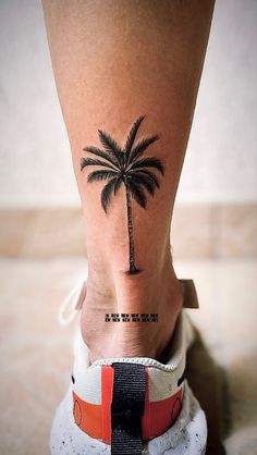 a woman's foot with a palm tree tattoo on it