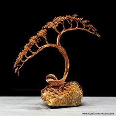 a golden tree sculpture sitting on top of a rock