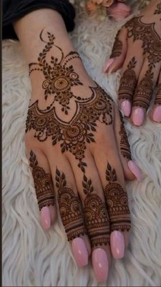 two hands with henna tattoos on them