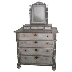 an old dresser with a mirror on top and drawers below it, against a white background