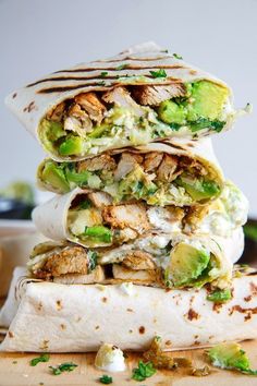 three burritos stacked on top of each other with chicken, broccoli and avocado