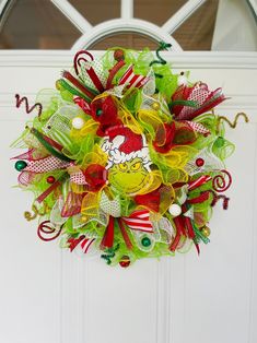 a christmas mesh wreath hanging on the front door with candy canes and candies