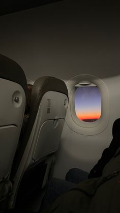 the view from inside an airplane window as it sits in the seat and looks out at the sunset