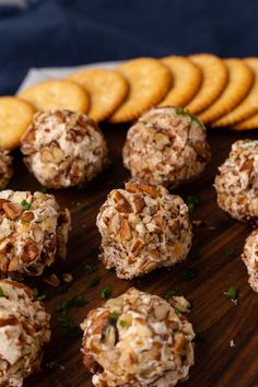 several cookies and crackers are arranged on a wooden platter next to some crackers