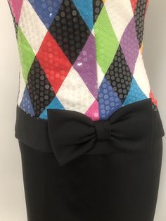 This is a strapless dress from Jenna Benjamin, USA. The bodice of the dress is a colorful harlequin pattern that is completely covered in clear sequins, giving it a lovely shine. The skirt is solid black and the low waist is accented with a bow. The dress zips in the back and is boned in the bodice. Size tag 6. Check measurements carefully, no stretch. Measurements taken with dress laying flat and doubled where appropriate. In order to determine fit we recommend comparing measurements with an it Black Party Dress For Carnival, Elegant Multicolor Strapless Evening Dress, Multicolor Fitted Strapless Dress, Multicolor Strapless Dress For Party Season, Elegant Fitted Multicolor Strapless Dress, Multicolor Fitted Strapless Dress For Cocktail, Multicolor Fitted Strapless Cocktail Dress, Fitted Multicolor Strapless Dress For Cocktail, Glamorous Multicolor Strapless Dress