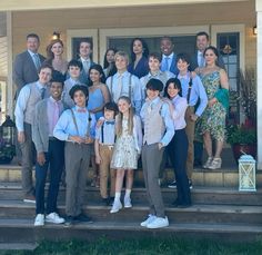 a group of people standing on steps in front of a house