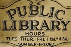 an old public library sign hanging on the wall