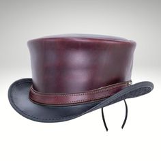 Mad Hatter Hat | Mad Hatter Maroon Top Hat | Mad Hatter top Hat - Made with genuine leather.  We presents the sleek and streamlined Maroon Leather Top Hat for those who prefer a simpler design. Tanned cowhide, the short, tapered crown is trimmed with a narrow leather strap; its massive brim flares up on the sides. This product is handmade with cowhide leather and is by expert craftsmen. This mad hatter hat is stylish and durable. The quality of this product is excellent. We guarantee that you wi Brown Leather Brimmed Fedora, Fitted Leather Hat With Curved Brim, Fitted Brown Leather Fedora, Adjustable Hat With Leather Lining And Curved Brim, Fitted Leather Hat With Short Brim, Classic Leather Top Hat With Short Brim, Classic Short Brim Leather Top Hat, Classic Flat Brim Hat With Leather Lining, Classic Leather Fedora With Flat Crown