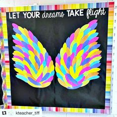 a bulletin board with an image of colorful wings and the words let your dreams take flight