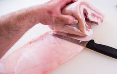 a person cutting meat with a large knife