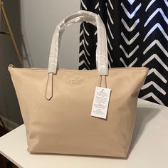 Brand New With Tags Attached. Kate Spade Large Tote. Warm Beige Color. With Leather Straps. Super Sleek And Cute Bag. Measurements: 17.32” D 11’h X 12’w Handle Drop 11.0” Top Zip Closure Interior: Back Zip & Front Slip Pockets Material: Recycled Nylon With Leather Straps Warm Beige Color, Bags Kate Spade, Warm Beige, Bag Measurements, Large Tote Bag, Cute Bag, Kate Spade Bags, Large Tote, Beige Color