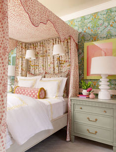 a bedroom with floral wallpaper and white bedding, two lamps on either side of the bed