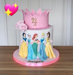 a birthday cake with princesses on it sitting on a table