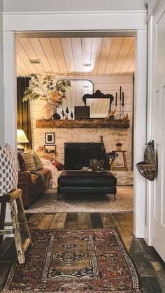 a living room filled with furniture and a rug on top of a hard wood floor