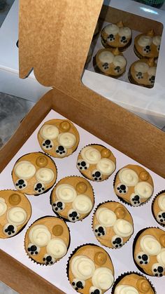 twelve cupcakes with white frosting and black dots in a brown cardboard box